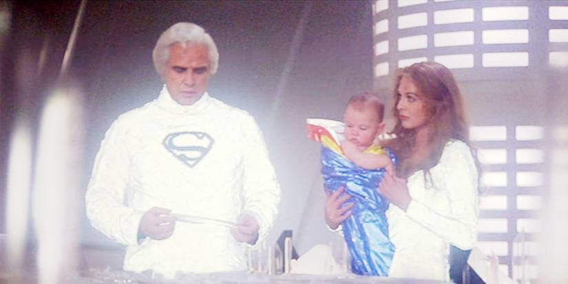 Jor-El holding a crystal as Lara Lor-Van holds Kal-El and looks at him in Superman The Movie
