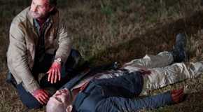 Rick squatting down next to a bloody Shane after killing him in The Walking Dead season 2.