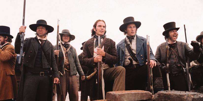Men in period costume look over a wall in The Alamo