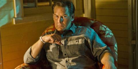 James Remar as Harry Morgan sitting in a chair on Dexter