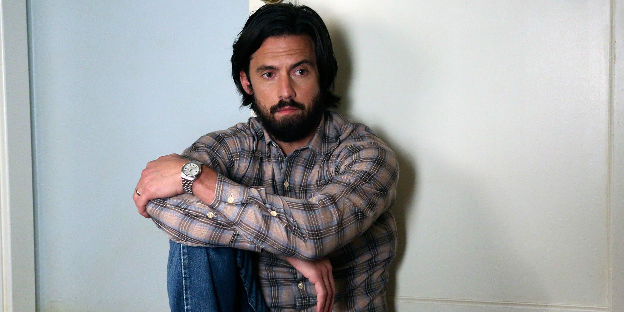 Jack Pearson sits on the floor with his arms folded on his legs in This Is Us