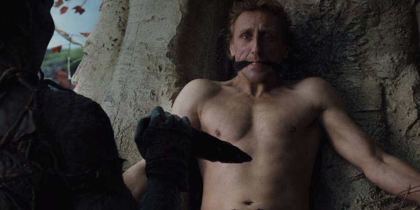 A man tied to a tree with Dragonglass held against him in Game of Thrones