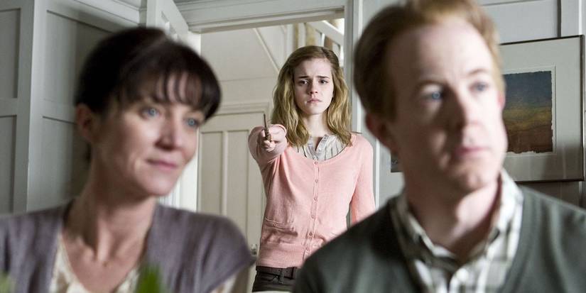 Hermione Granger visible behind her parents as she raises her wand to them in Harry Potter and the Deathly Hallows Part 1
