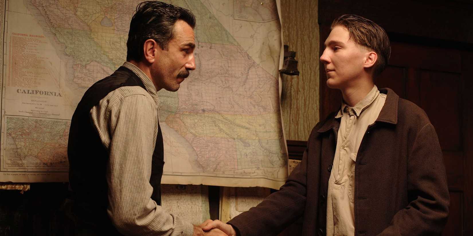 Eli Sunday (Paul Dano) e Daniel Plainview (Daniel Day Lewis) apertando as mãos em Sangue Negro