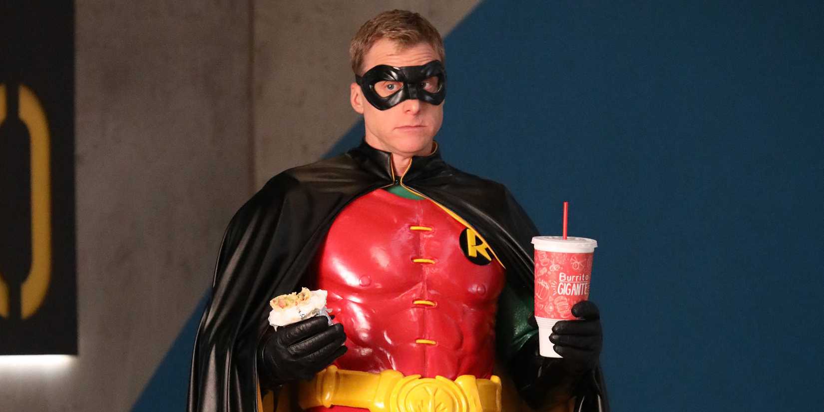  Alan Tudyk as Van Wayne, dressed in a Robin suit and holding takeout in Powerless 
