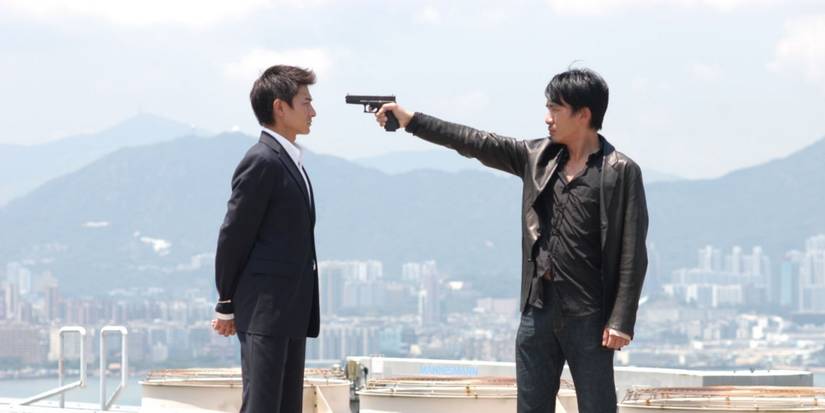 Seorang pria menodongkan senjata ke pria lain di Infernal Affairs