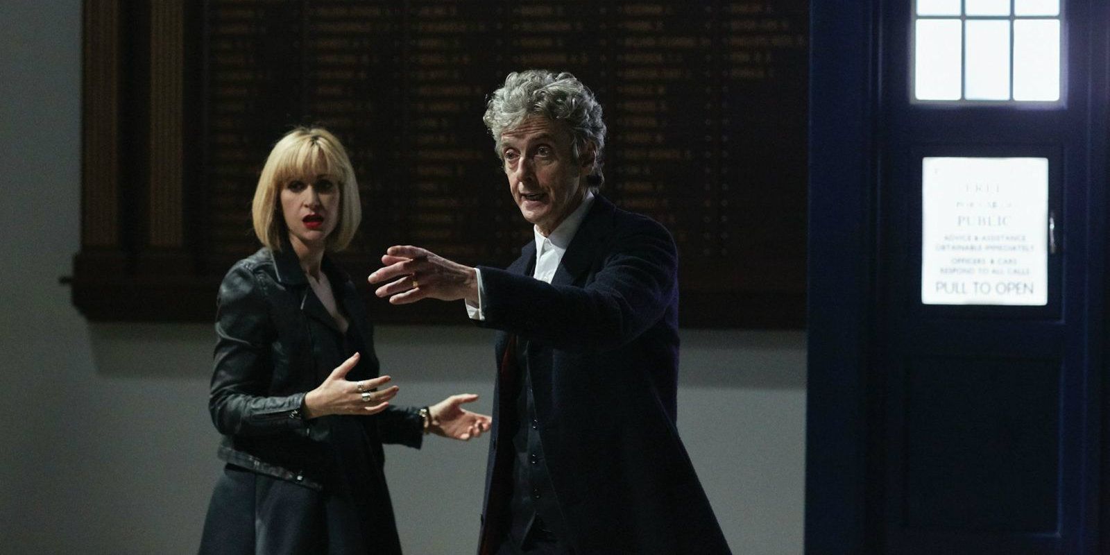 Peter Capaldi's Doctor standing outside the TARDIS and pointing off to the side beside Katherine Kelly in Class