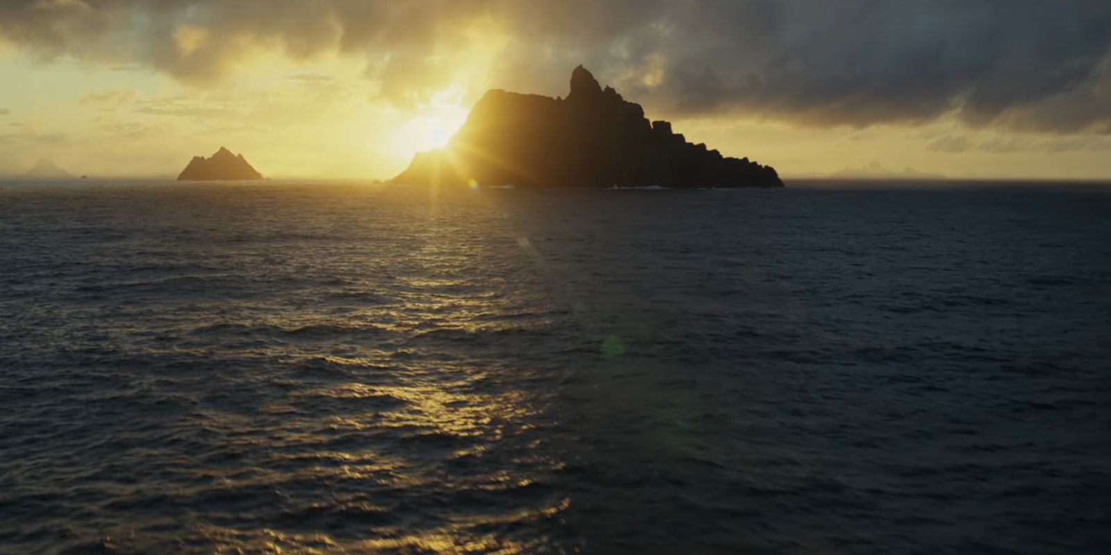 A shot of Luke Skywalker's island on Ahch-To from a distance with a sunrise in the background.