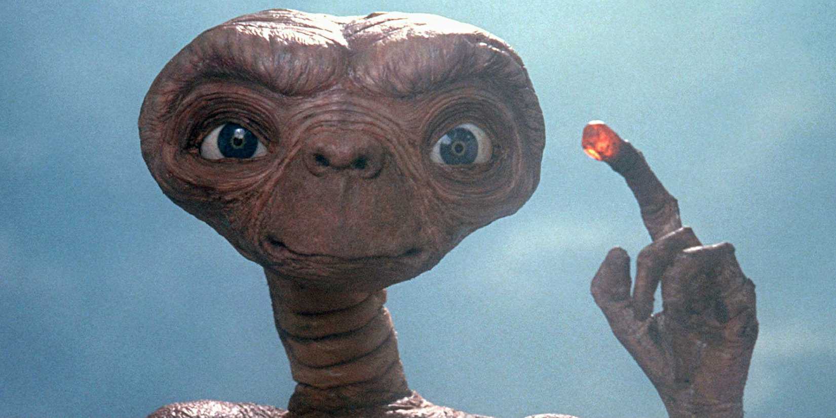 E.T. segurando o dedo que brilha.