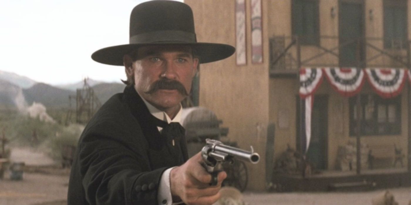 Kurt Russell as Wyatt Earp holding a pistol in Tombstone