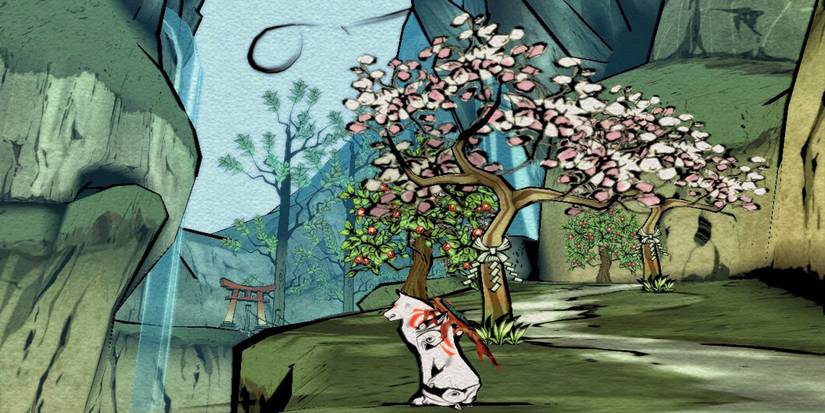 The wolf Amaterasu sits next to a blooming tree in Okami.