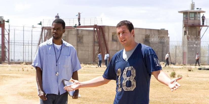 Chris Rock as Caretaker and Adam Sandler as Paul Crewe standing in the yard together in The Longest Yard.
