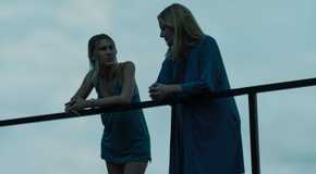 Sofia Hublitz as Charlotte and Laura Linney as Wendy Byrde leaning against a rail in Ozark