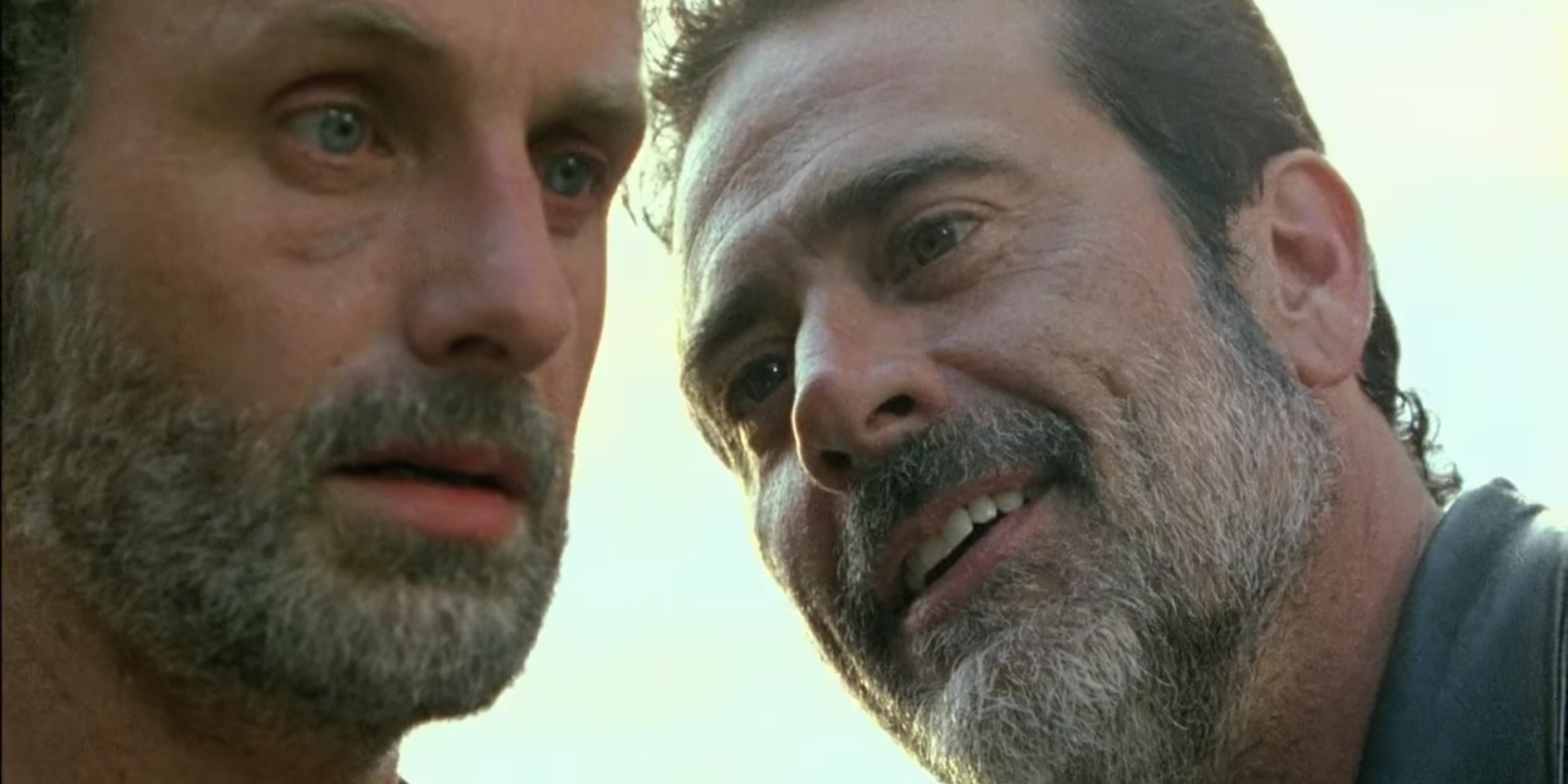 Negan smiles at Rick while Rick faces forward, looking stunned