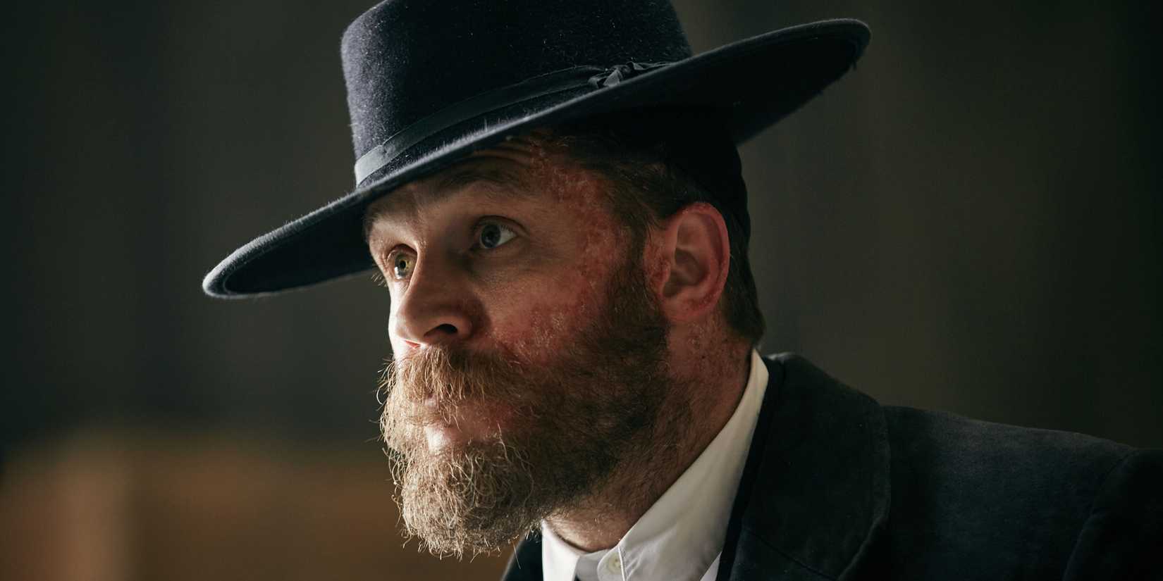 Tom Hardy como Alfie, olhando com curiosidade em Peaky Blinders