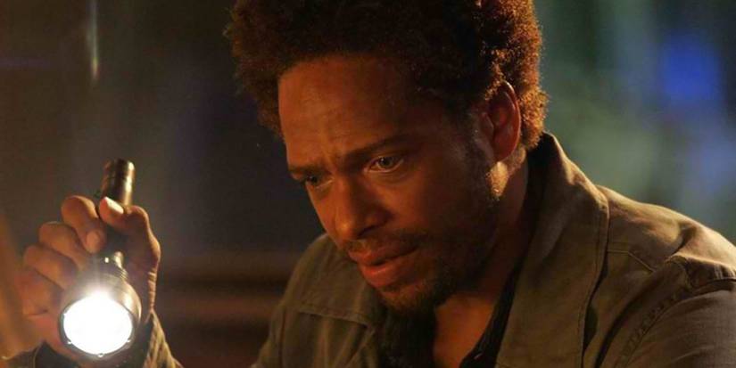 Gary Dourdan as Warrick Brown using a flashlight to examine something out of frame in CSI