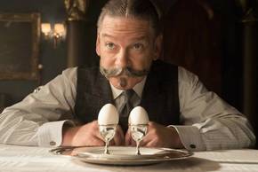 Kenneth Branagh as Hercule Poirot inspects two eggs in Murder on the Orient Express