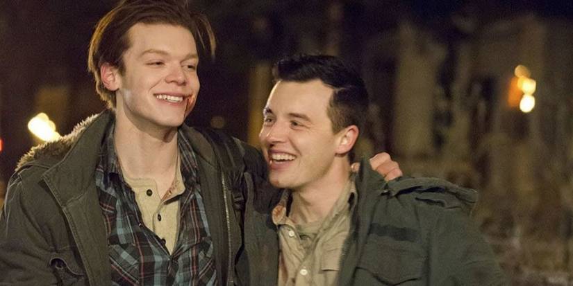 Ian and Mickey laughing on the street at night in Shameless