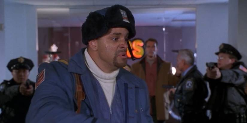 Sinbad as a postman with cops behind him pointing their guns in Jingle All The Way