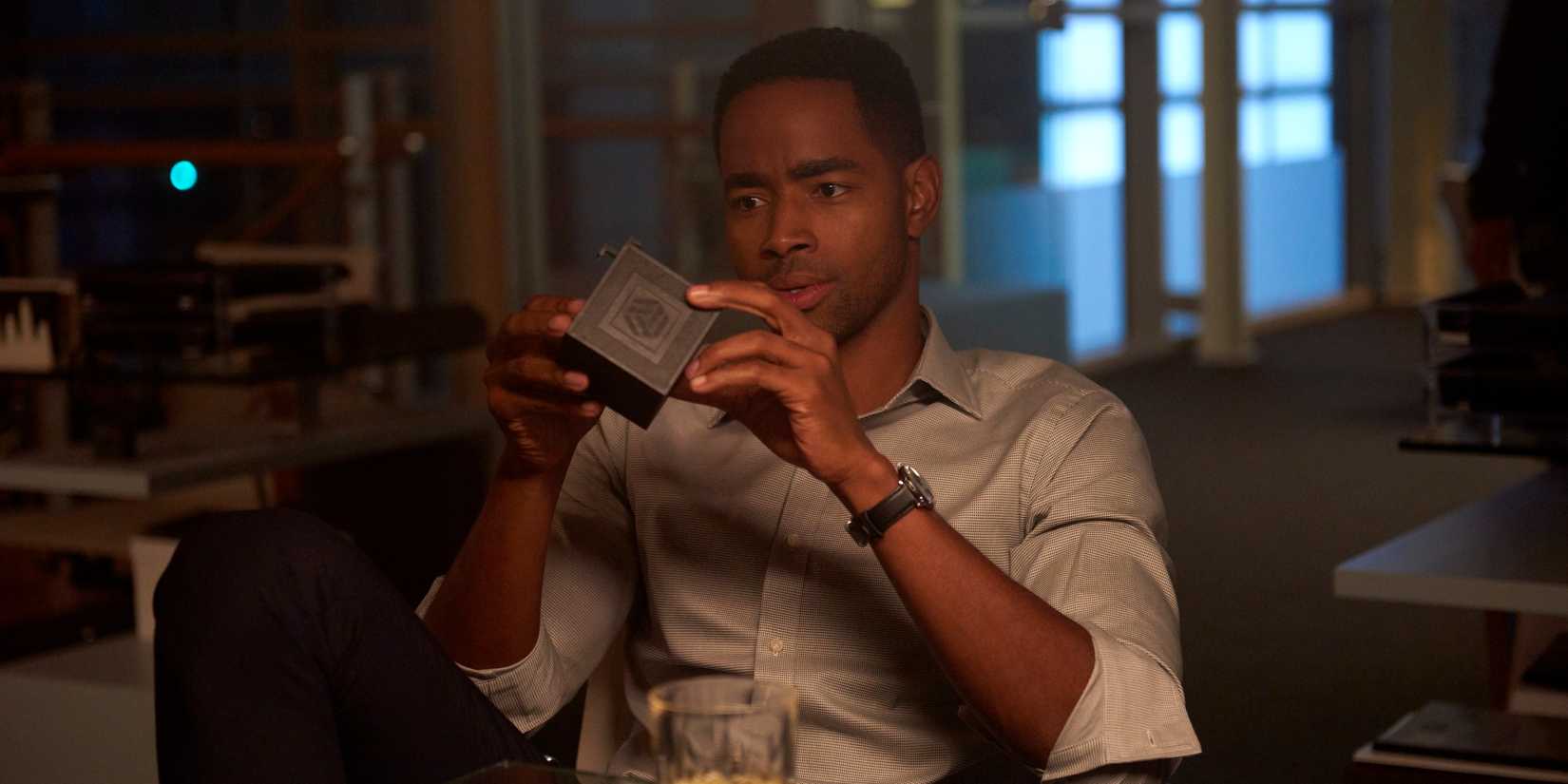 Jay Ellis playing with a cube in Escape Room