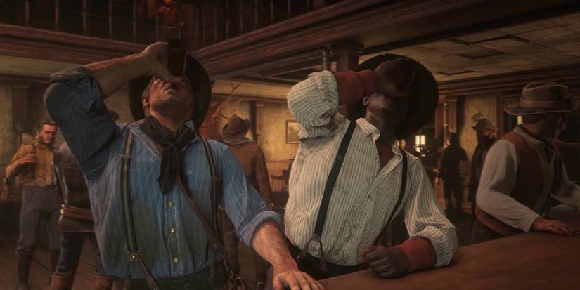 Arthur Morgan and Lenny downing drinks at a bar in Red Dead Redemption 2