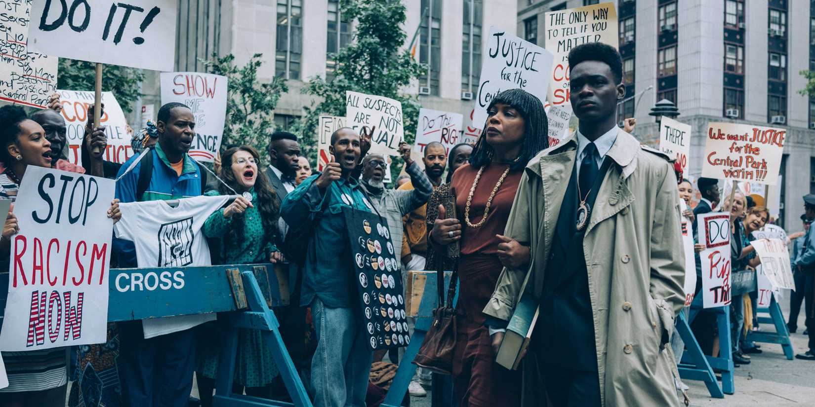Ethan Herisse como Yusef Salaam e Aunjanue Ellis como Sharon Salaam com manifestantes em When They See Us