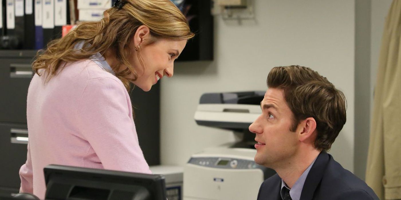 Jim ajoelhado para conversar com Pam sorridente na 9ª temporada de The Office