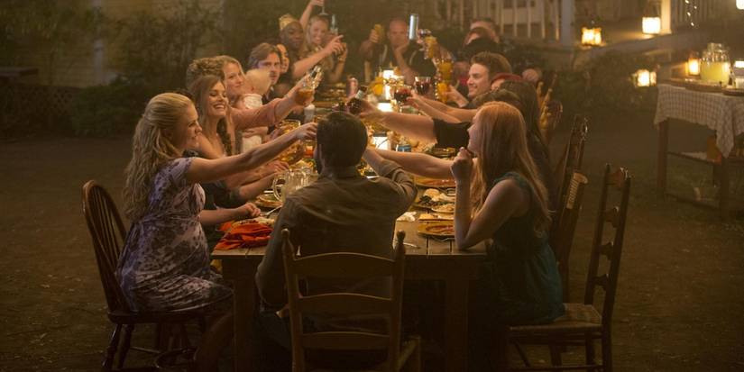 Personagens ao redor de uma mesa fazendo um brinde no final de True Blood