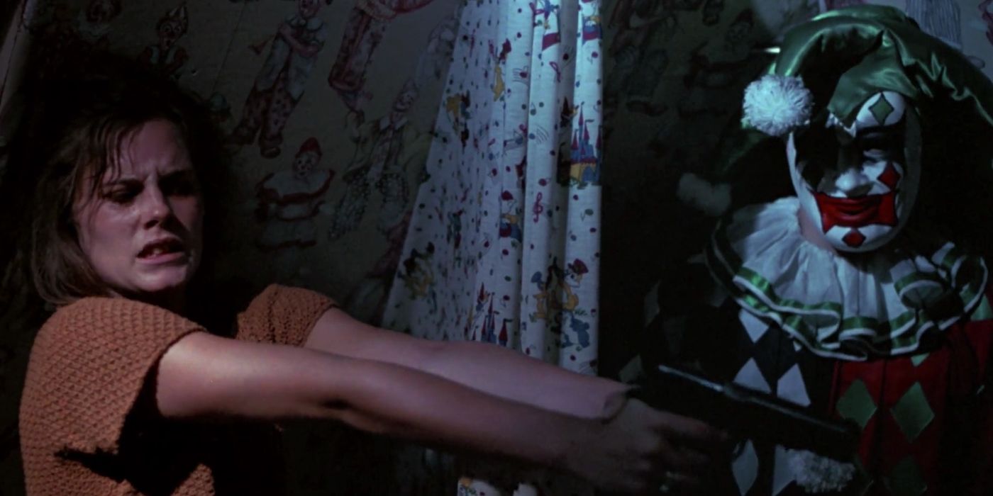 A woman points a gun at night next to a creepy jester doll in The House on Sorority Row.