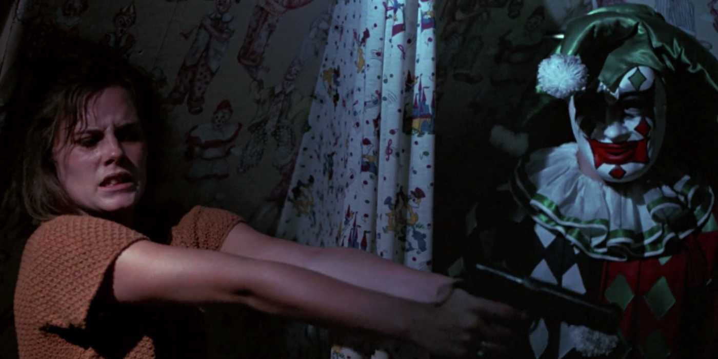 A woman points a gun at night next to a creepy jester doll in The House on Sorority Row.