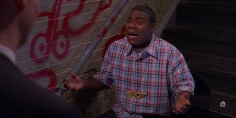 Tracy Jordan looking shocked and scared while sitting on a staircase in 30 Rock