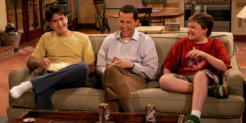 Charlie (Charlie Sheen), Alan (Jon Cryer), and Jake (Angus T. Jones) sitting on the couch on Two and a Half Men.