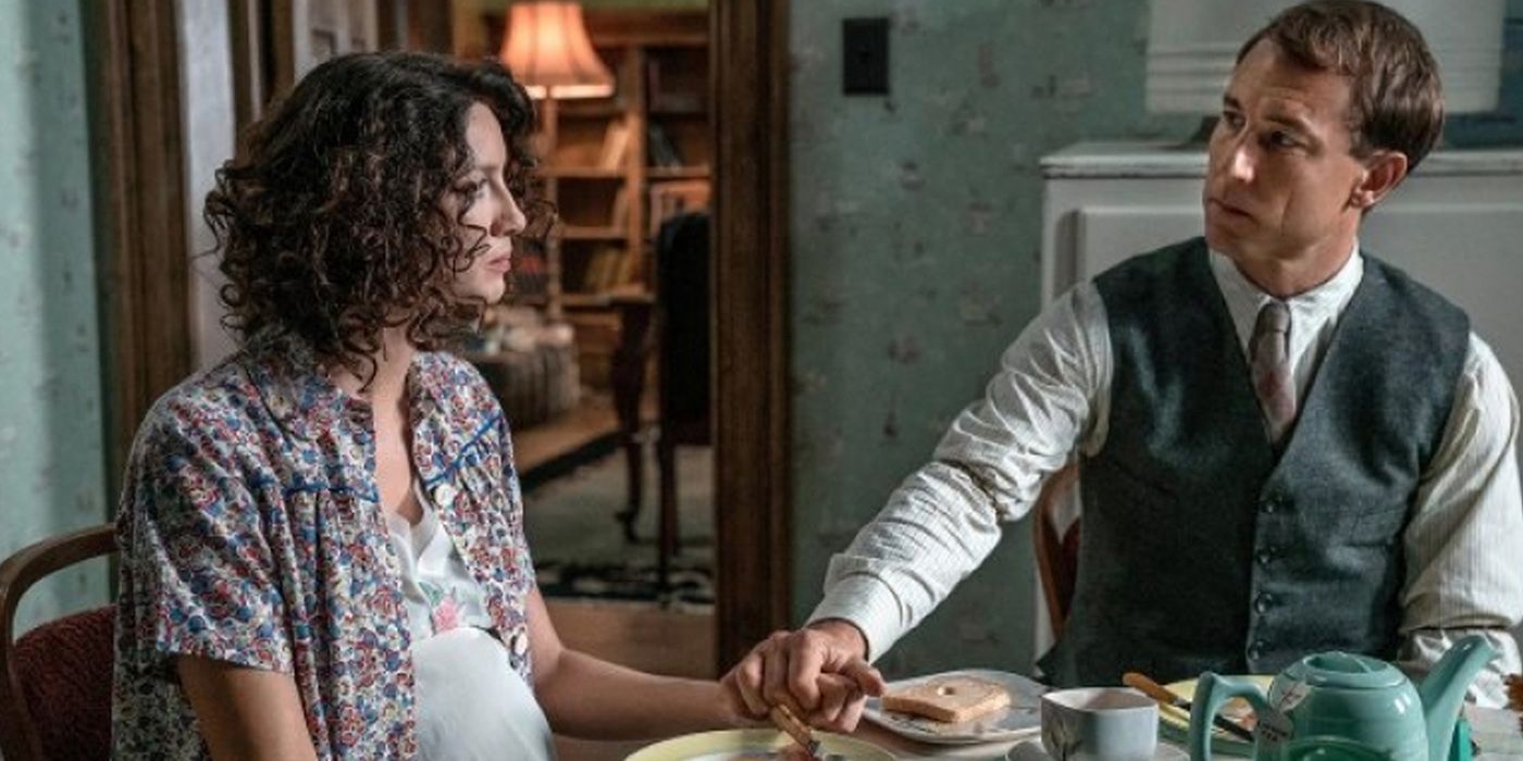 Frank and Claire holding hands while eating breakfast in Outlander.