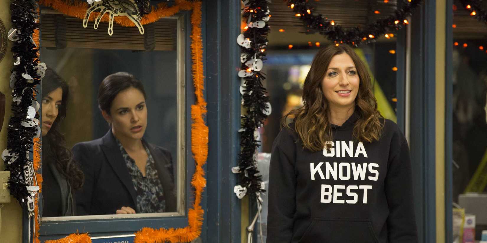 Amy and Rosa look at Gina from behind a door in Brooklyn 99