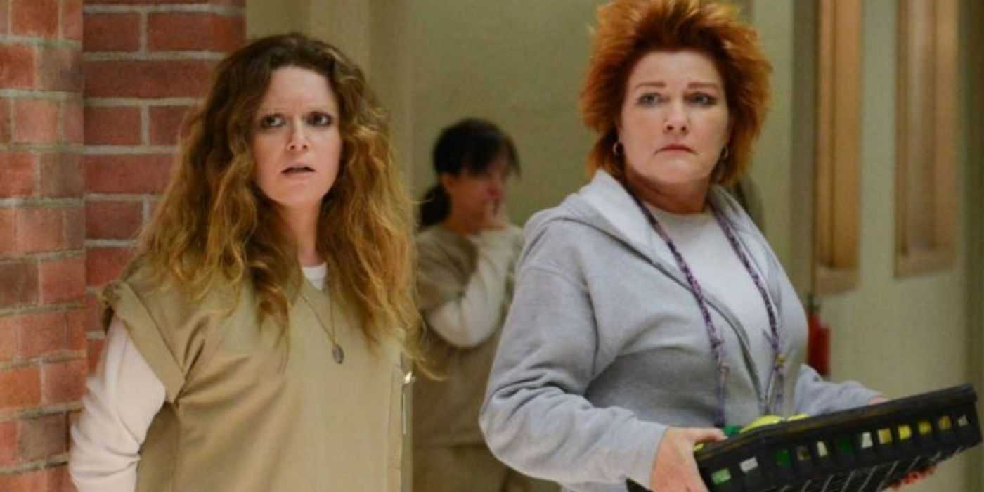 Nicky (Natasha Lyonne) looking scared and Red (Kate Mulgrew) holding a crate of lemons and limes in OITNB