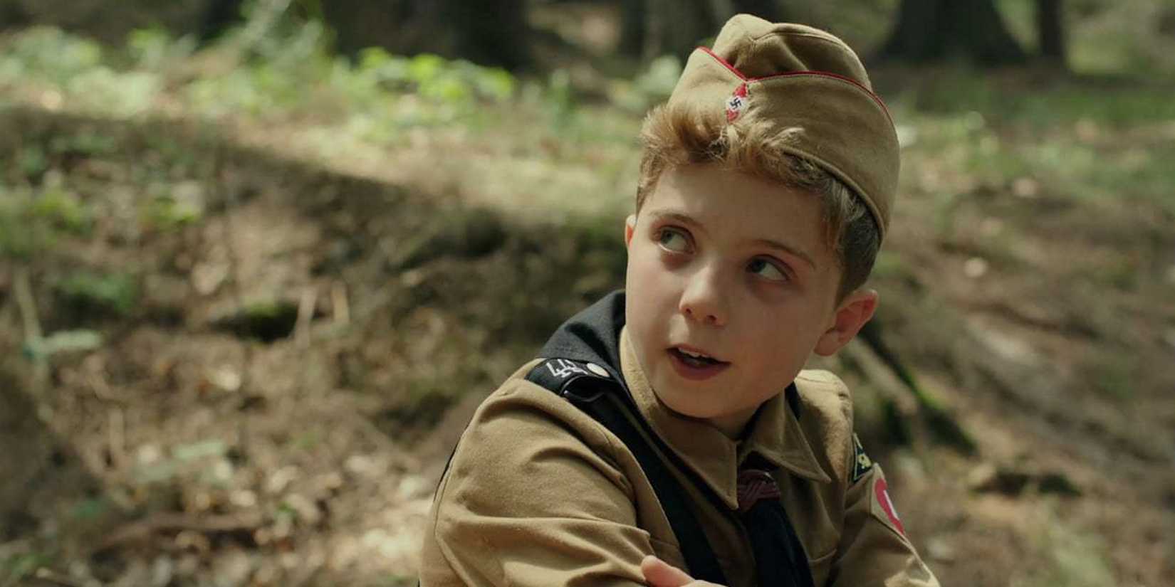 Jojo in his Nazi Youth uniform turning to his right in Jojo Rabbit