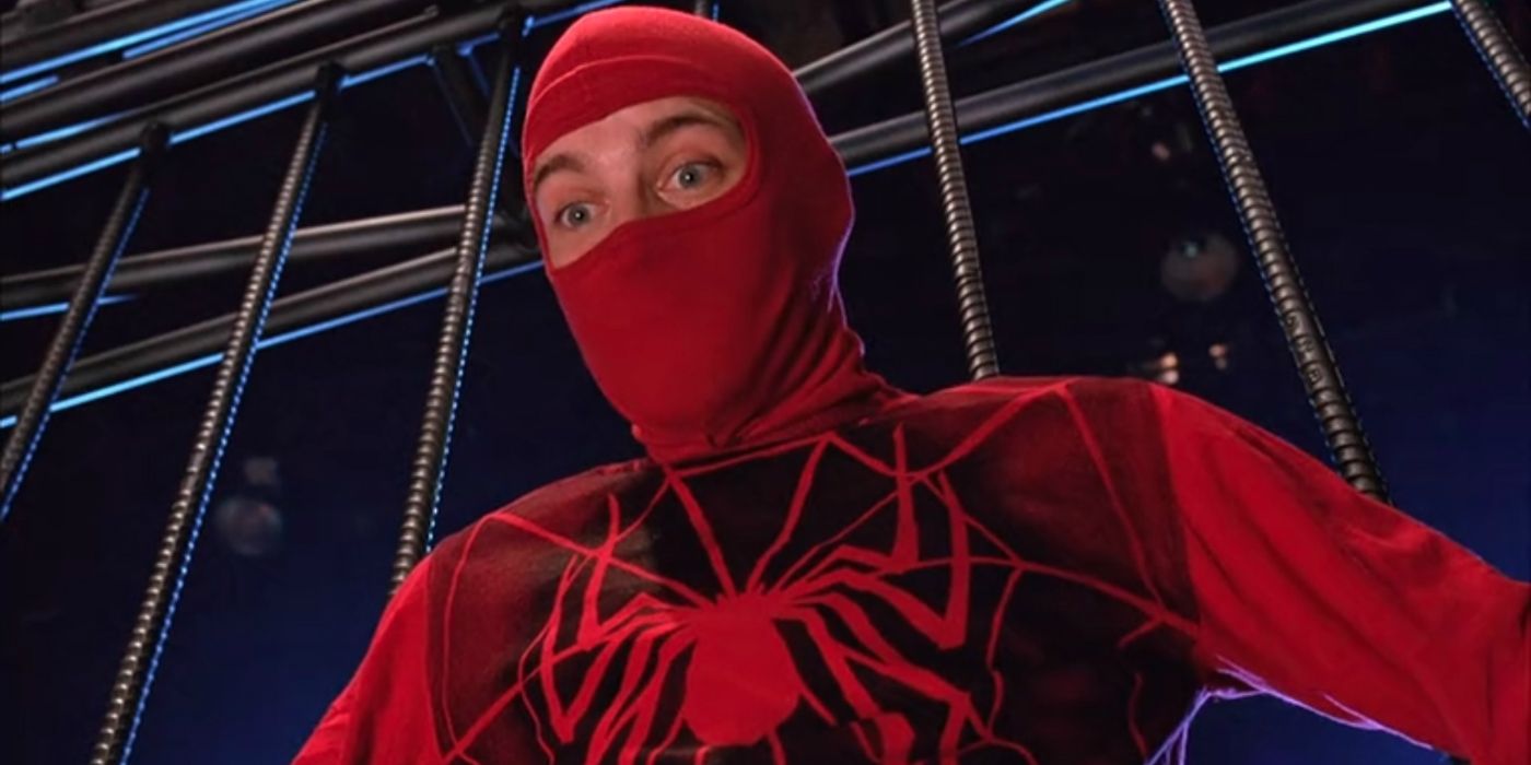 Close-up of Tobey Maguire's Spider-Man in a homemade suit clinging to the bars of a wrestling cage in Spider-Man (2002)