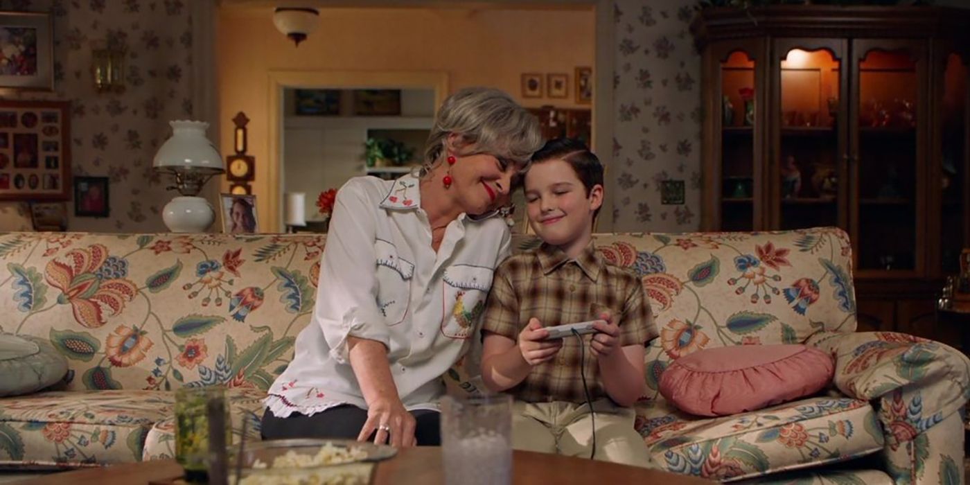 MeeMaw doting over Sheldon sitting on the couch in her home in a scene from Young Sheldon.