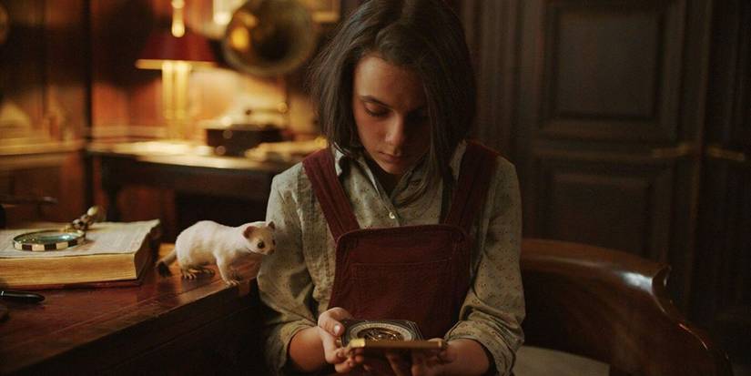Lyra and Pan looking at something together in His Dark Materials.