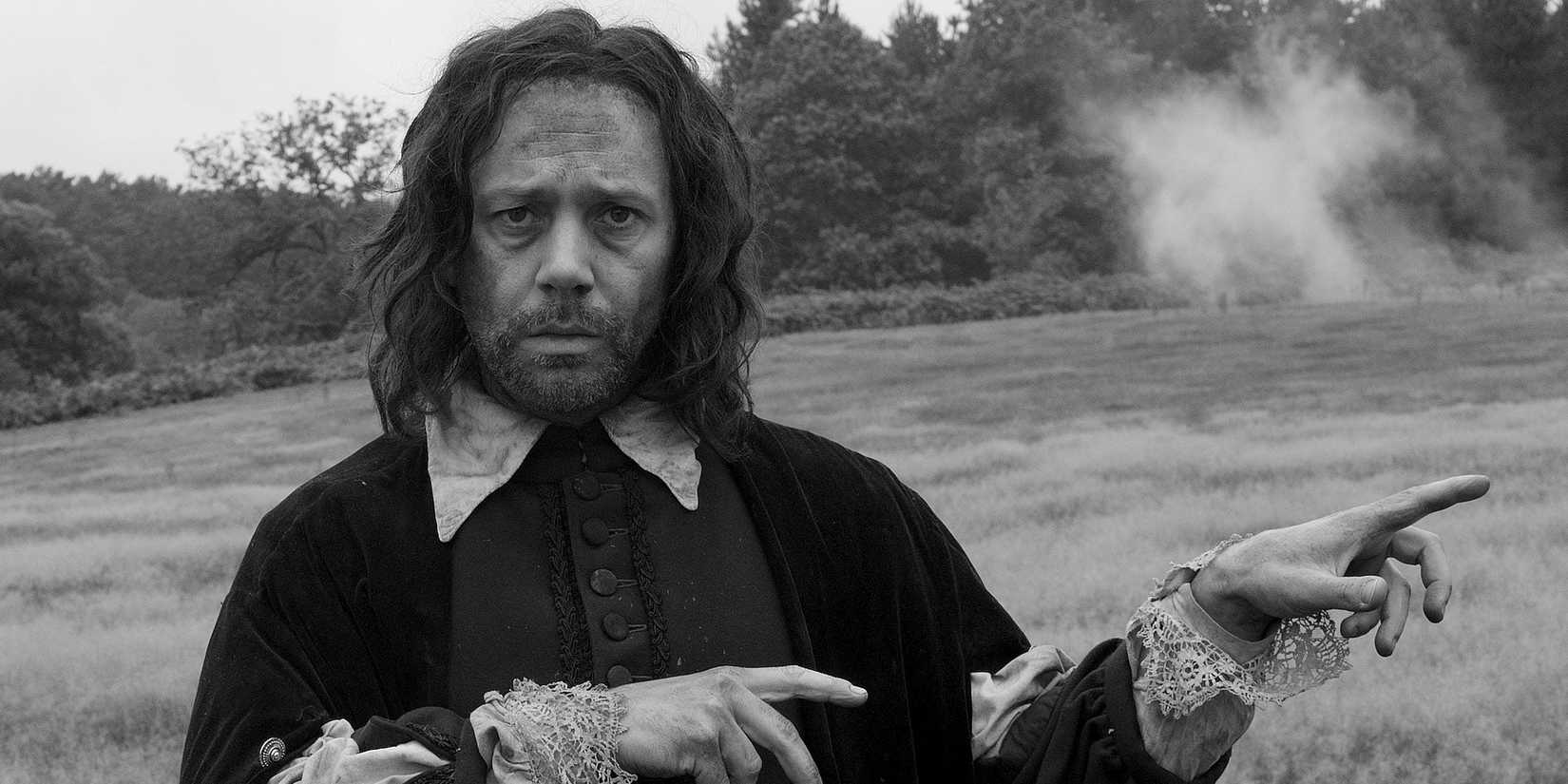 Reece Shearsmith apontando para fora de quadro em A Field in England