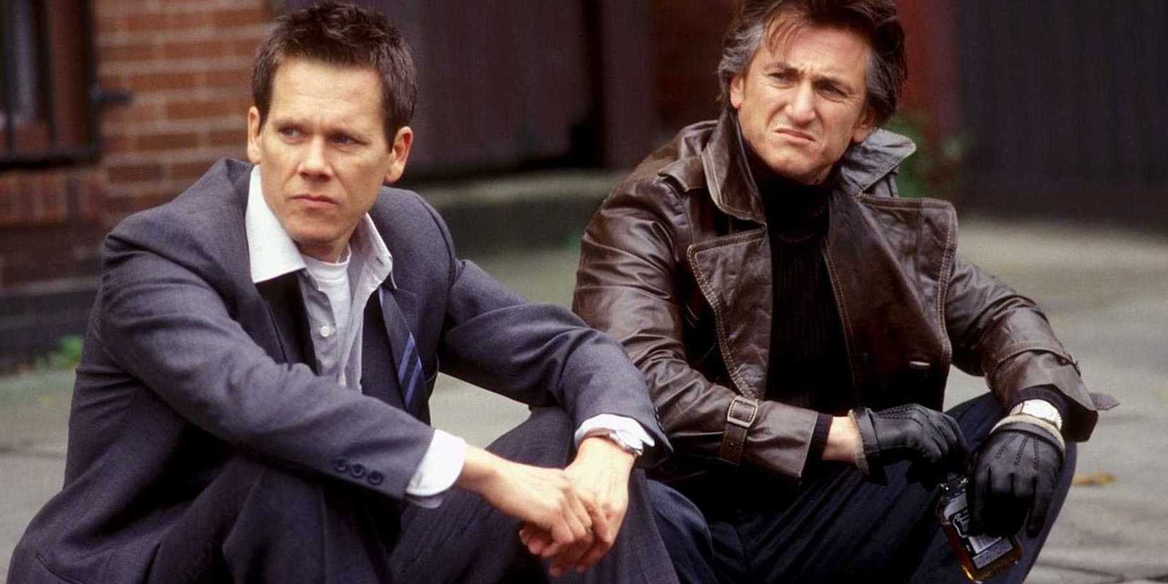 Jimmy and Sean sit on a sidewalk in Mystic River
