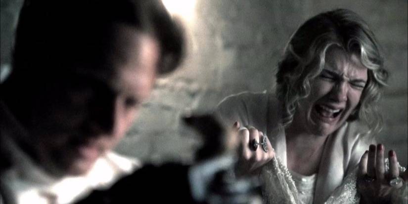 Charles Montgomery in the forefront while Nora cries in the background in AHS Murder House