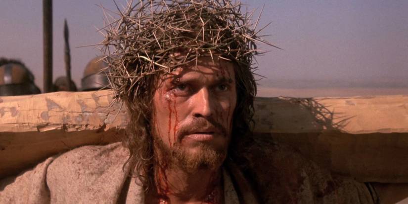 Willem Dafoe as Jesus holding the cross in The Last Temptation of Christ