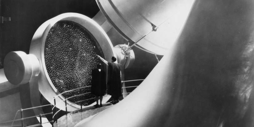 Two people look through a portal in Things to Come