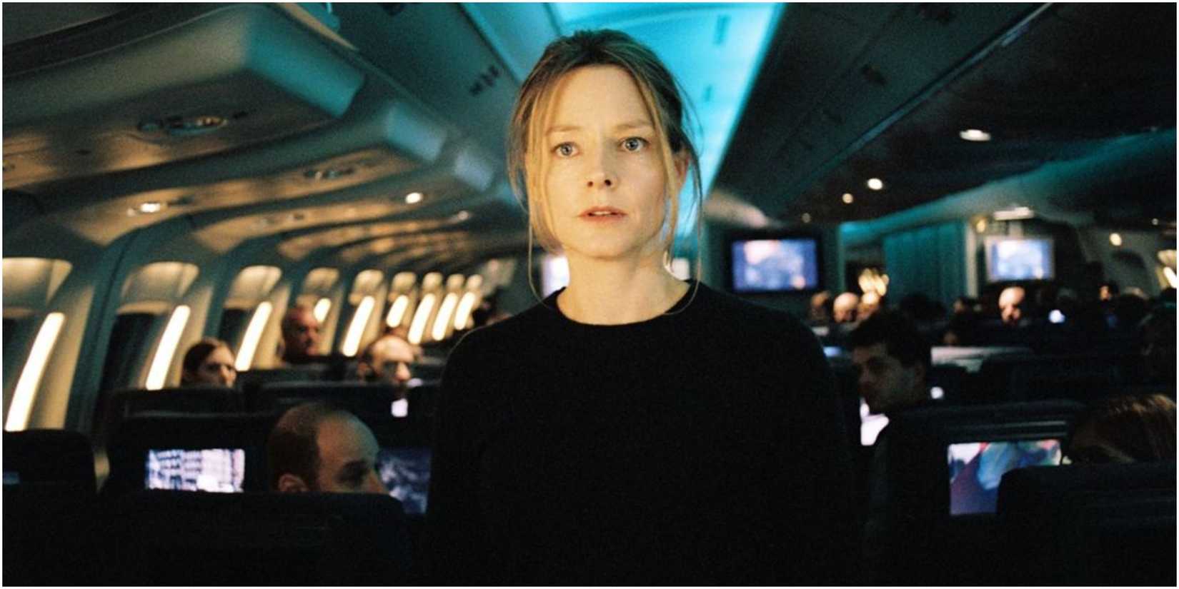 Jodie Foster stands in a packed airliner looking forward dramatically in a scene from Flightplan