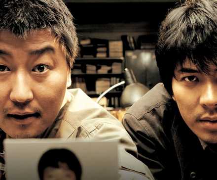 Два мужчины, делящиеся фотографией в фильме "Воспоминания о убийстве".