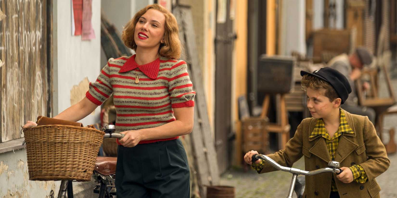 Scarlett Johansson sebagai Rosie dan Roman Griffin Davis sebagai Jojo berjalan dengan sepeda mereka di Jojo Rabbit