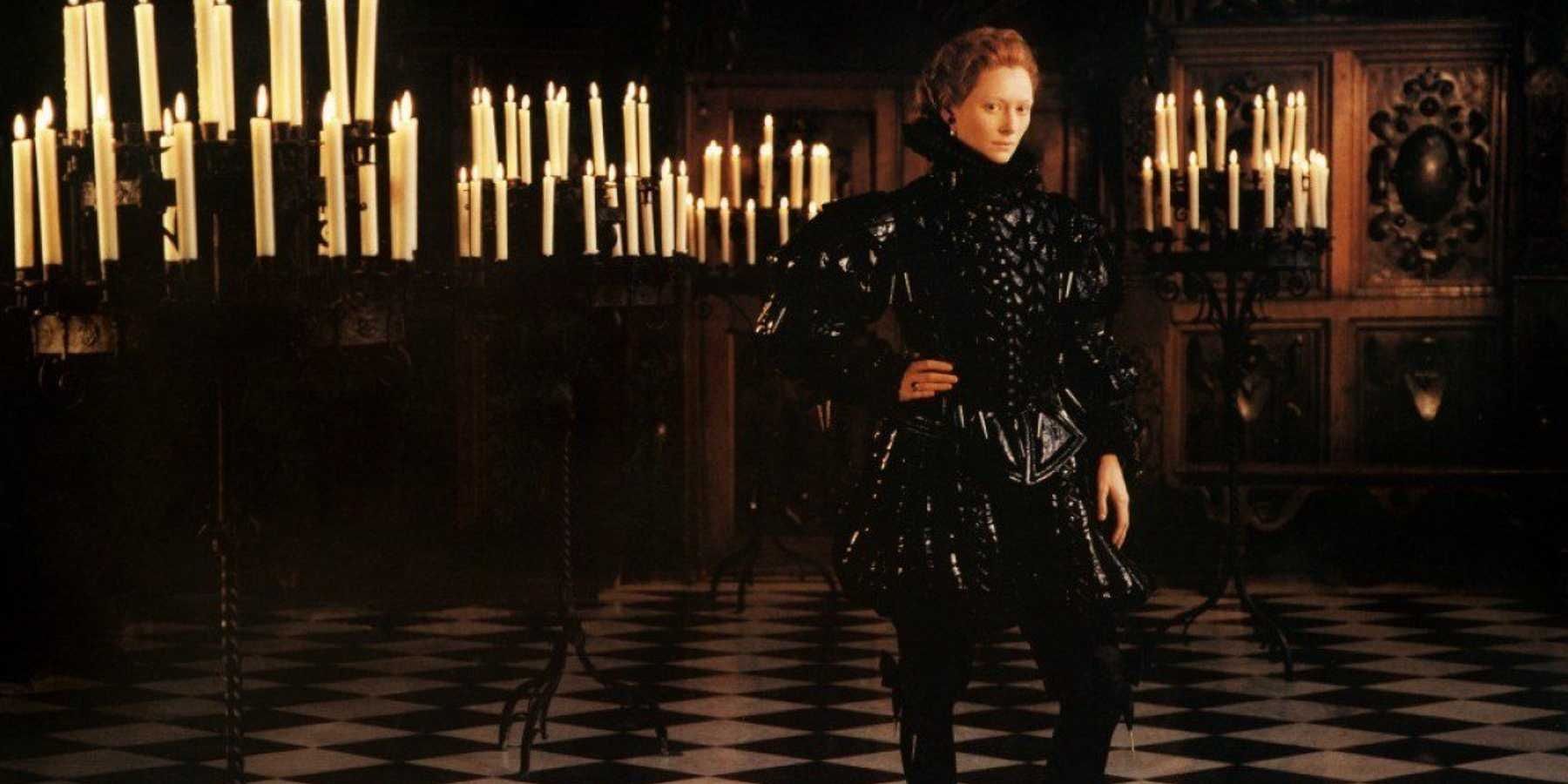 Tilda Swinton as Orlando posing in a room filled with candles in Orlando