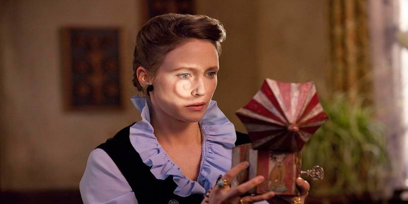 Лоррейн смотрит в музыкальную шкатулку в фильме *The Conjuring*.