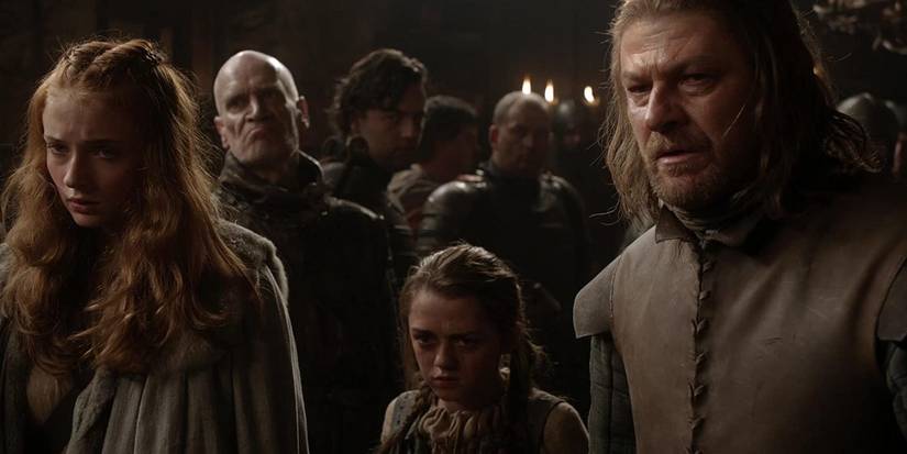 Sansa, Arya, and Ned standing before King Robert